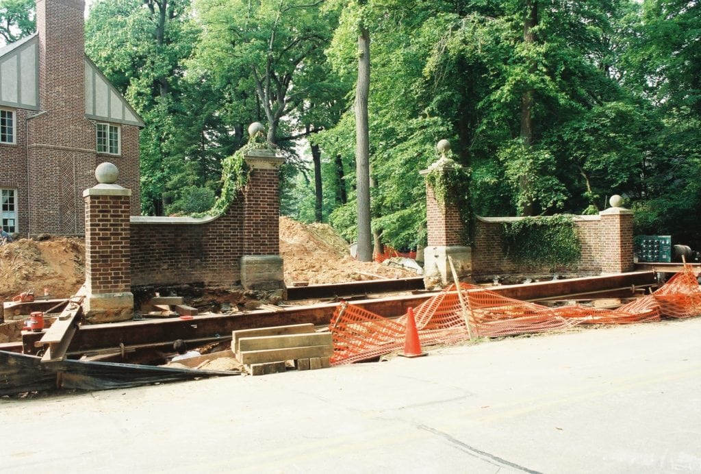 Enterance way brick pillars with vines lifted on steel beams.