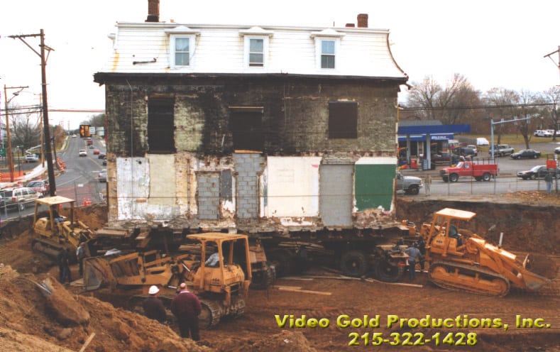 Spread Eagle Inn raised on dolly surronded my excavation equipment.