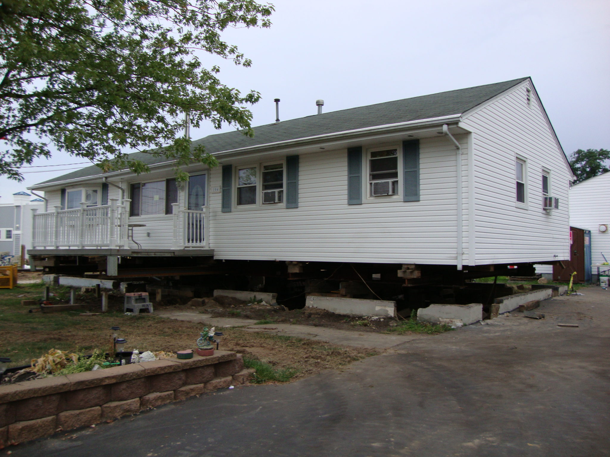 Single story house raised off of foundation resting on steel beams.