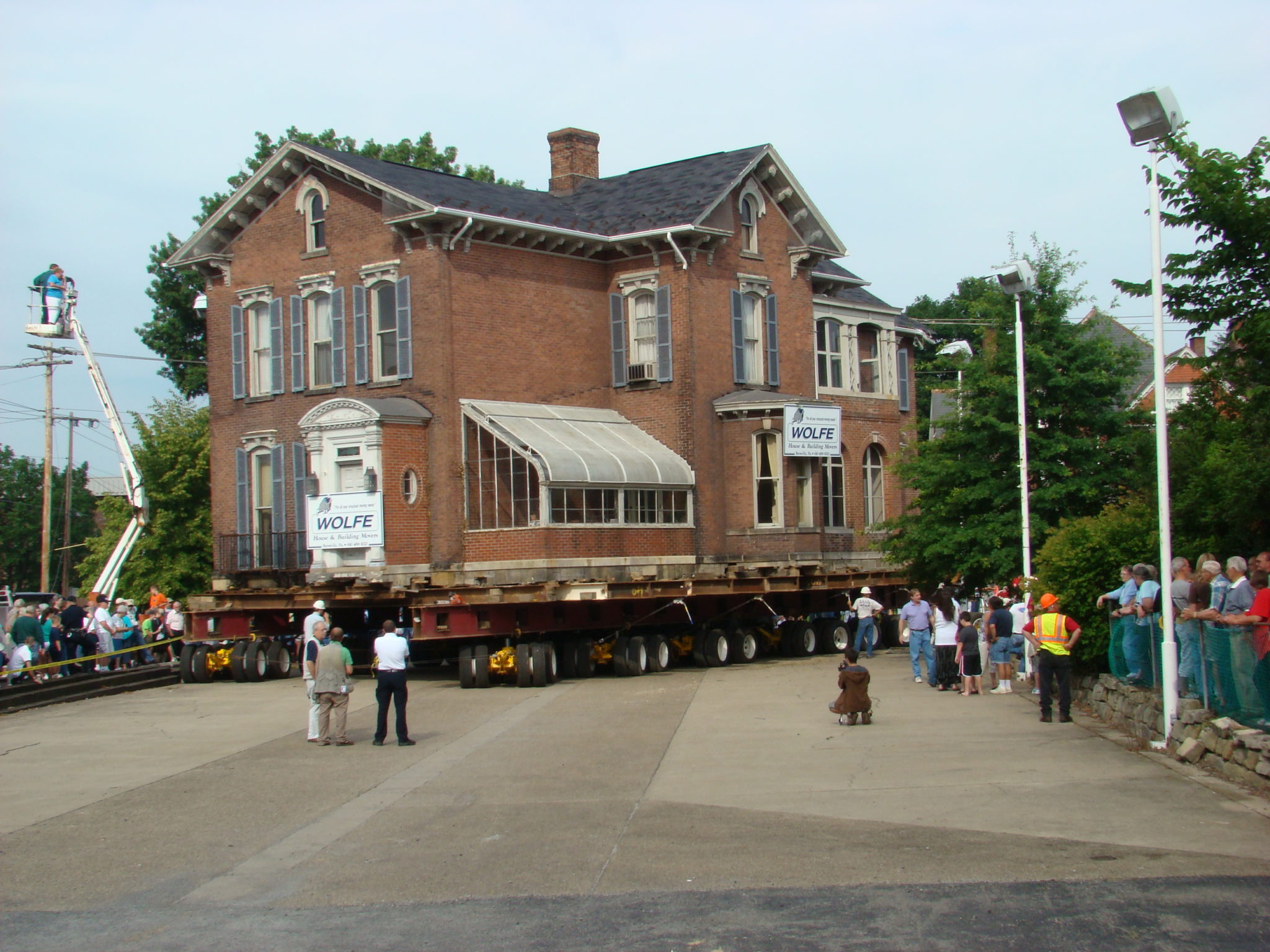 Troutman House, two story brick house moving on dolly through streets with bystanders.