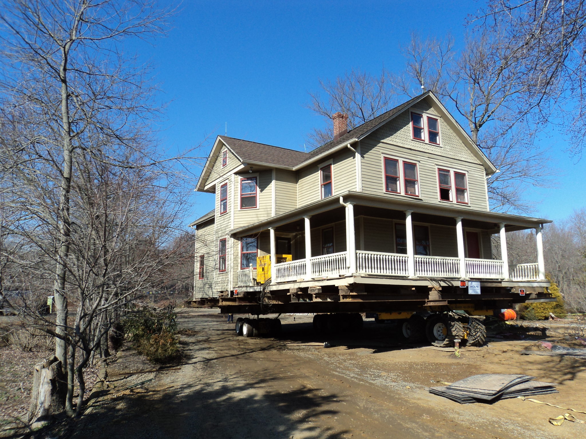 Victorian farmhouse raised on dolly moving through wooded environment.