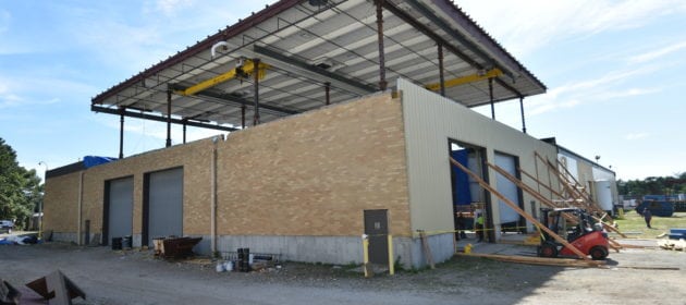 Roof of warehouse lifted 20 ft off structure ground view.