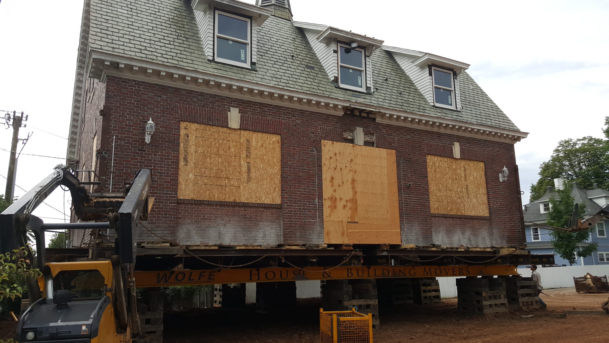 Historic, red brick, carriage house raised on supports.