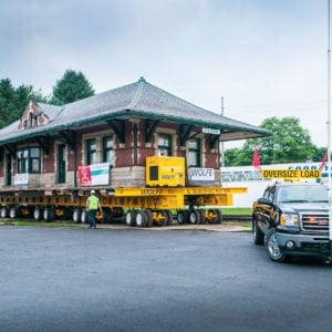 Gmc truck in front of the Sturgis train depot, which is raised on a dolly.
