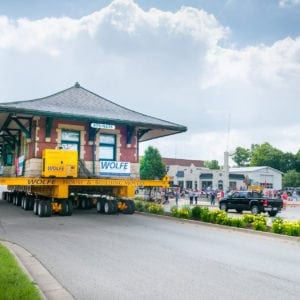 Sturgis Railroad depot moving through a town, on a dolly, with a crowd watching.