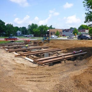 A mostly empty construction site with a foundation under construction.