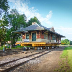 Workers rearrange blocks as Sturgis railroad depot moves across train tracks.