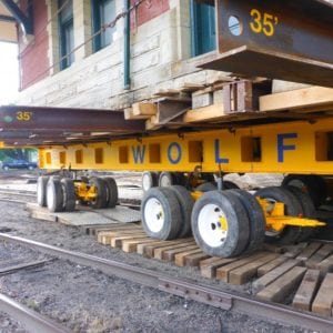 Wooden blocks laid across rail road with dolly moving across.
