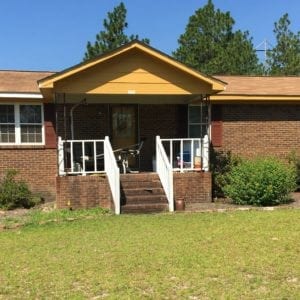 Single story brick house with a small, raised, brick porch.
