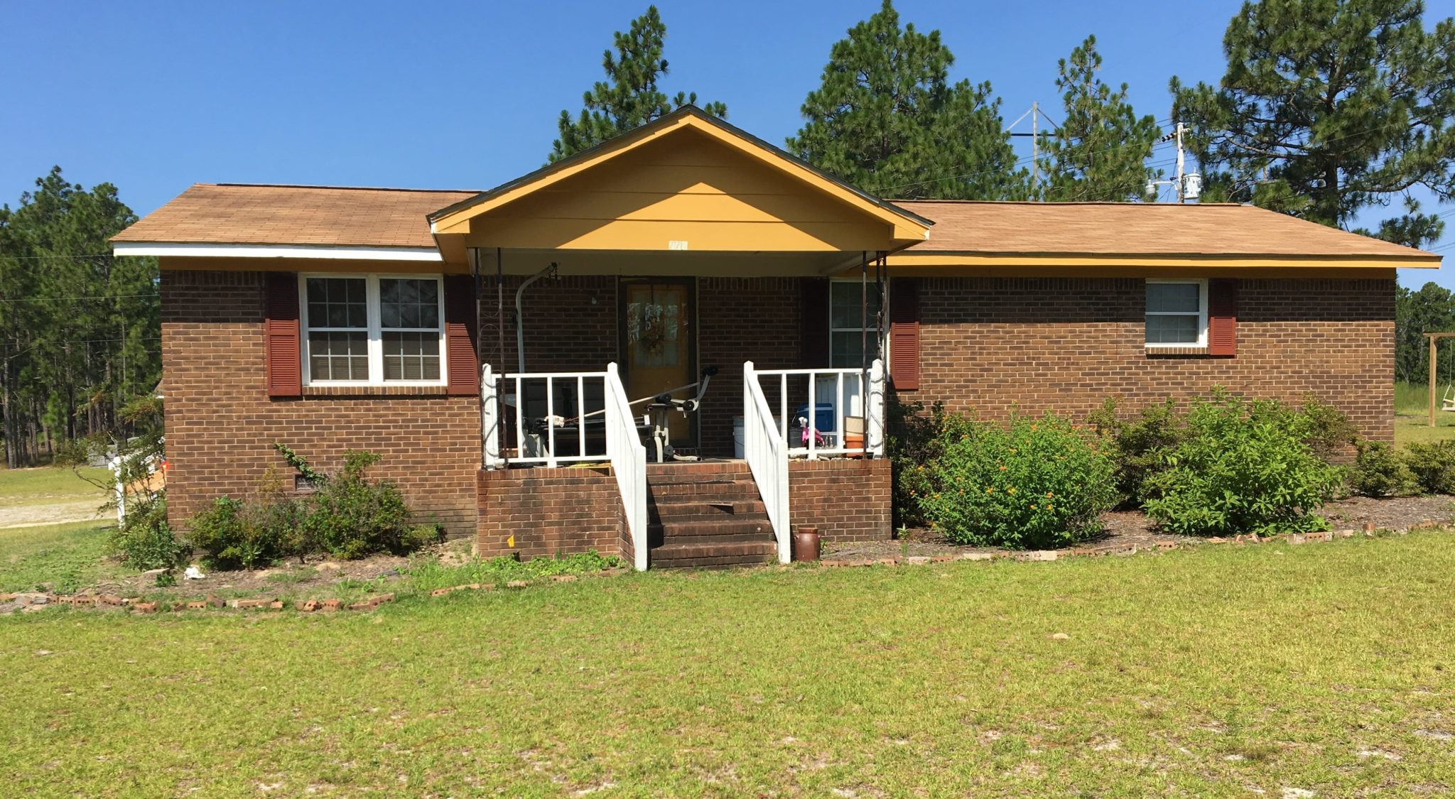 Single story brick house with a small, raised, brick porch.