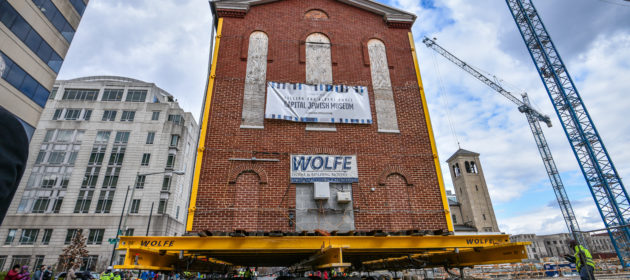 Jewish historic synagogue on dolly moving through city streets.