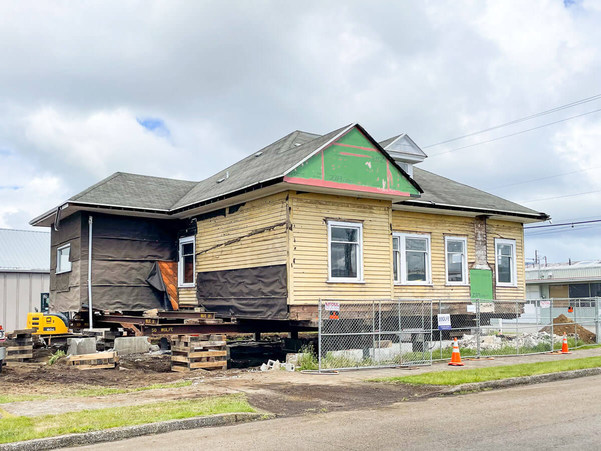 Wolfe excavates beneath the house and builds crib piles to lift the house 5'