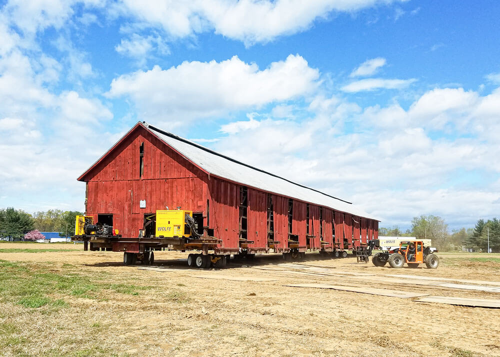 Wolfe moves a red tobacco barn across a field