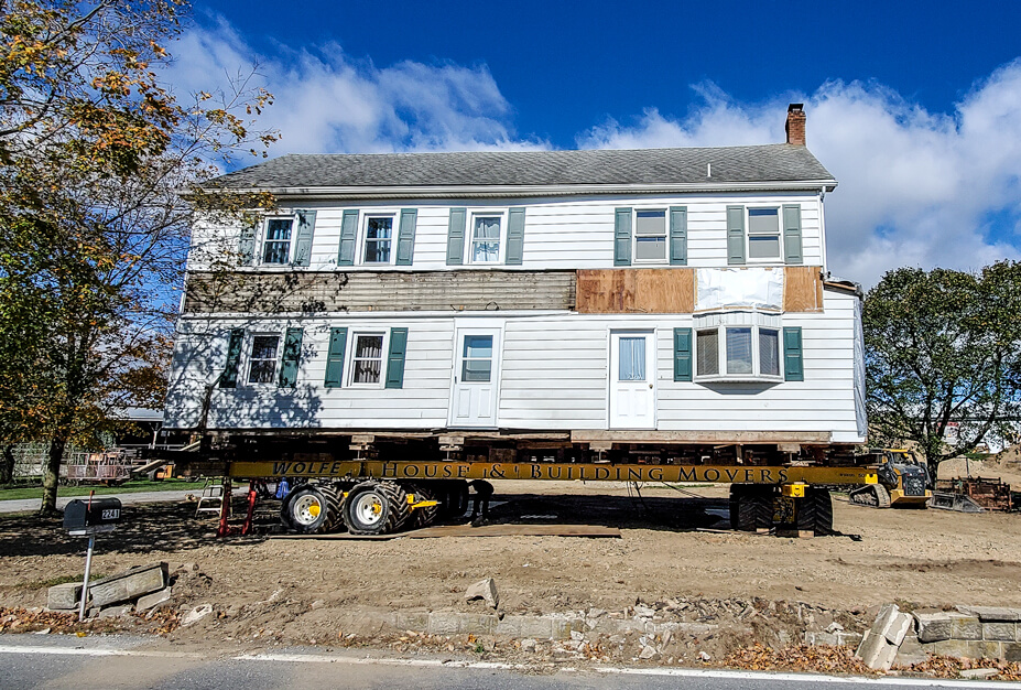 Frame Farmhouse Being Driven to New Location