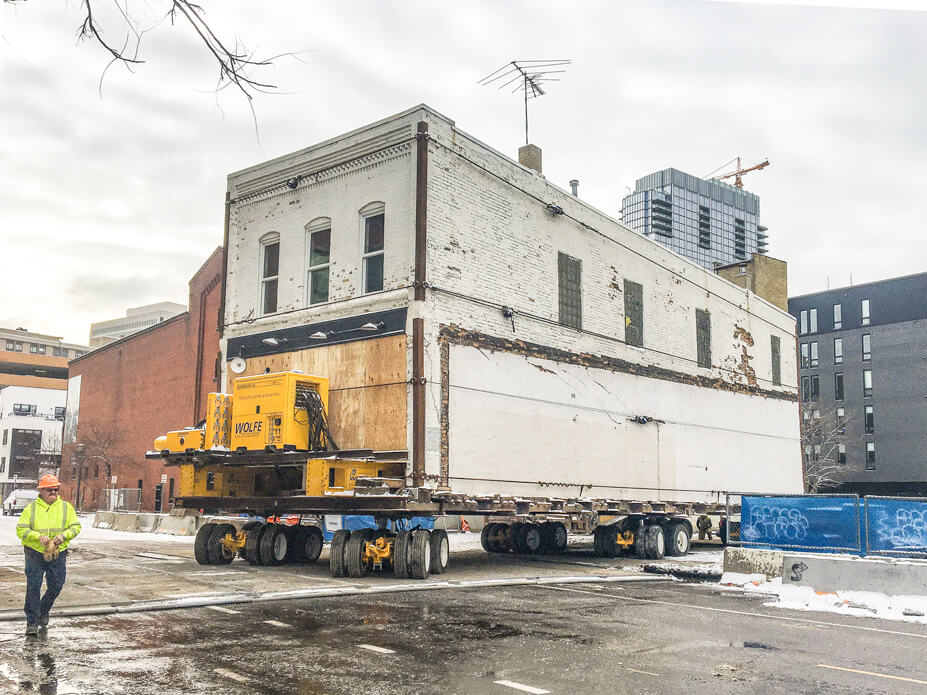 the foreman steers a 22'x66' building around a corner and into the street 