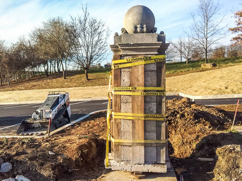The stone pillar with bracing sits on its new foundation