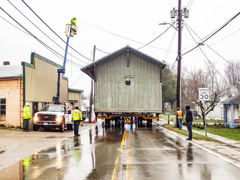 Crews lift wires for the Akron depot to pass under