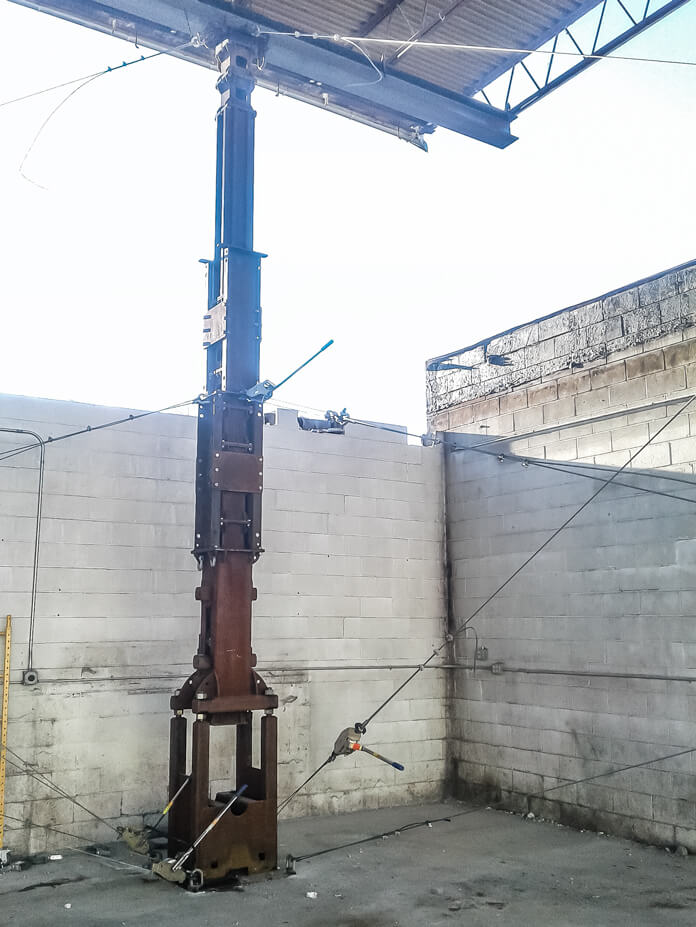 A tower jack supports a corner of a roof building