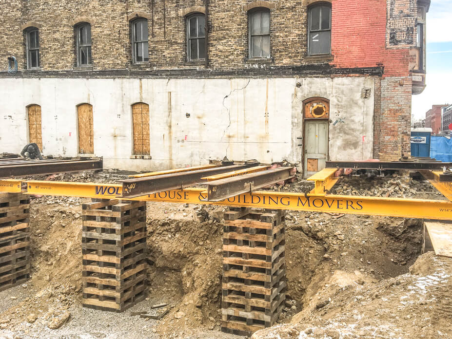 Crib and steel support a brick building wall