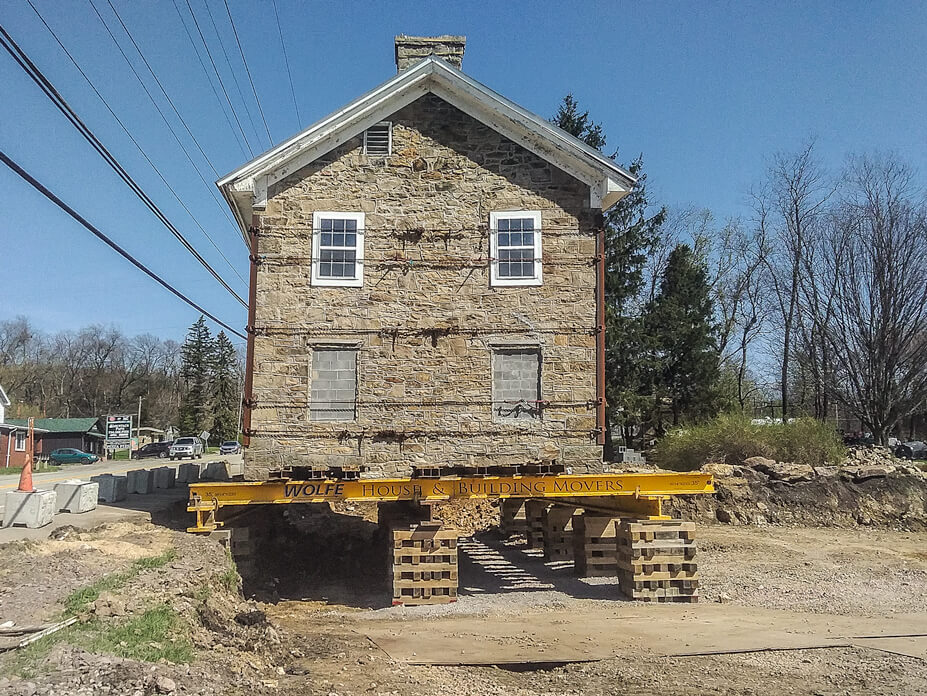 End view of stone house on cribbing