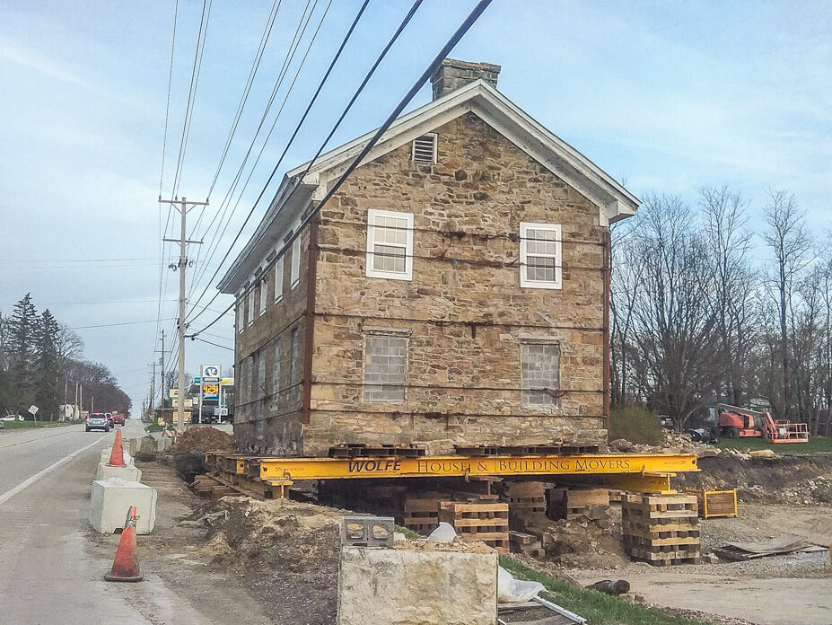 Stone house sits on cribbing waiting to be moved