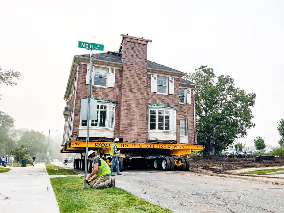 Workers remove road signs from the move route of the May House
