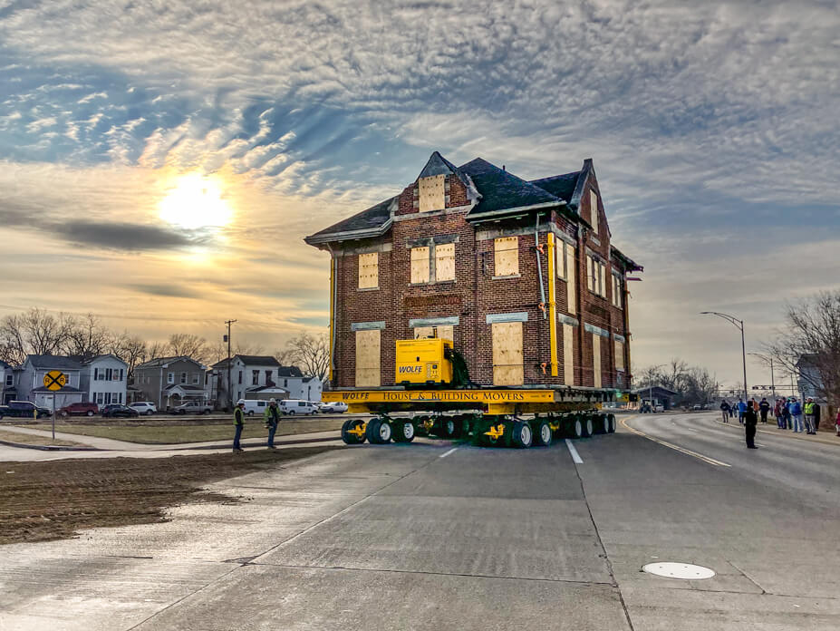 The sun is setting behind the Hamilton Depot as a Wolfe foreman drives it onto the new lot