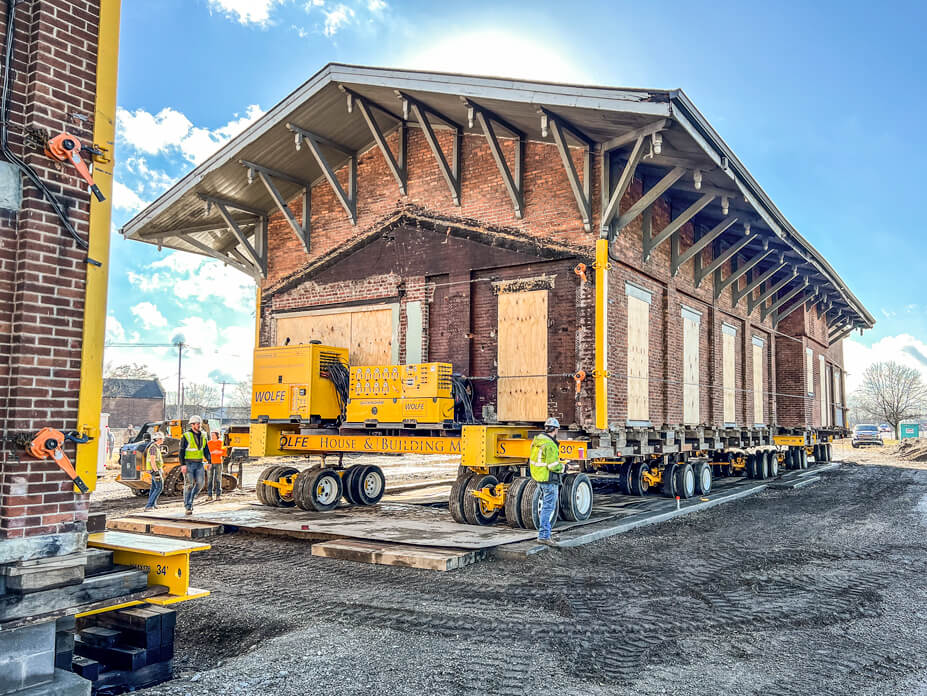 The 1-story Hamilton Depot sits on dollies over the footers of its new foundation
