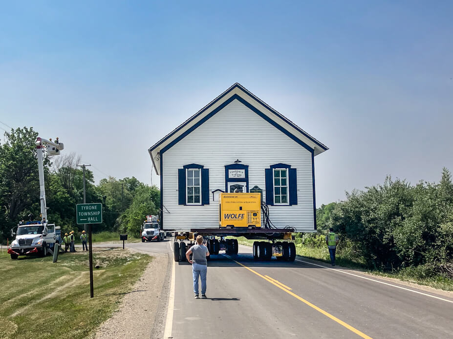 The Tyrone Township Building is driven down the center of the road by a Wolfe foreman