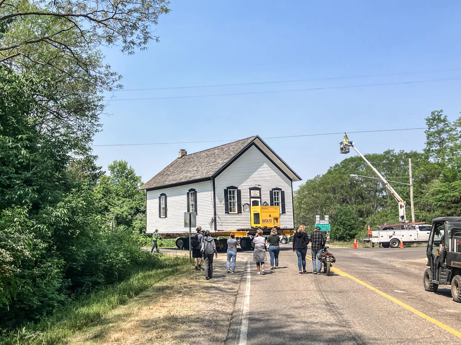 Townspeople watch as the the Tyrone Township Building is moved to its new location