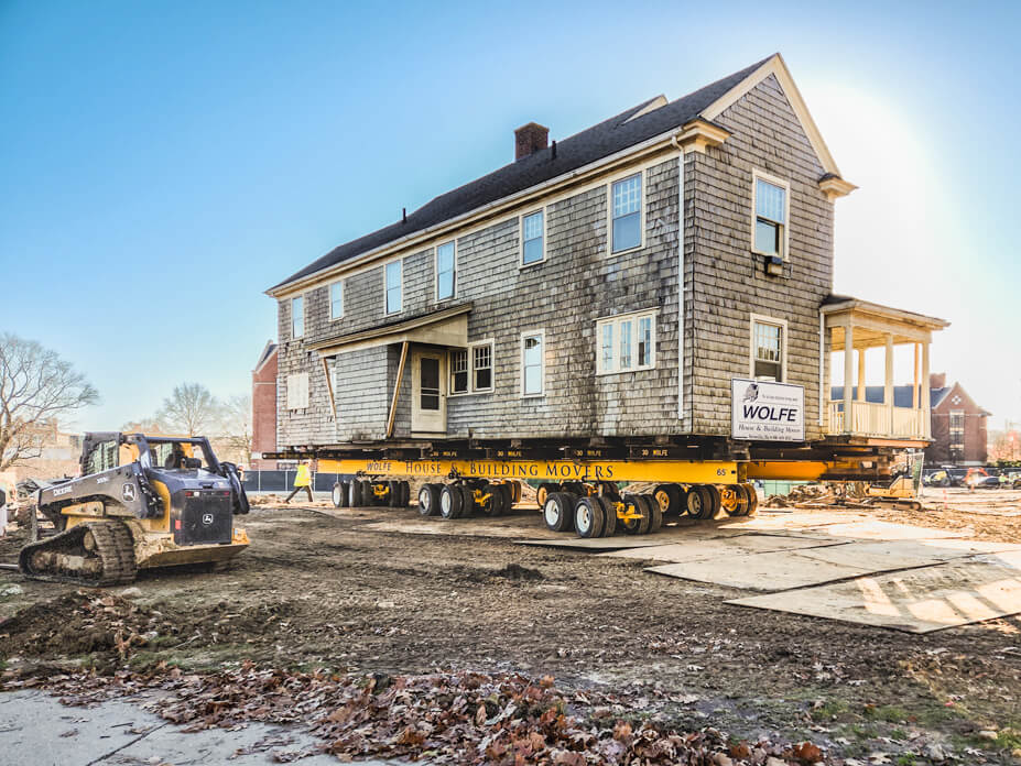 Wolfe House Movers drives a UConn house over steel plate to its new location