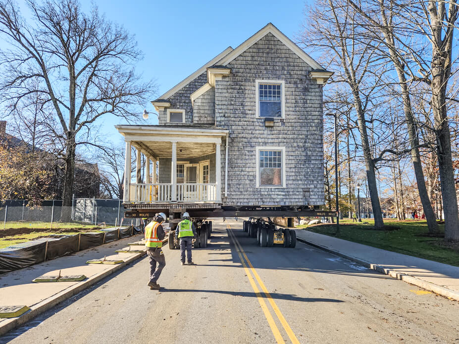 End view of UConn house being driven down street by Wolfe foreman