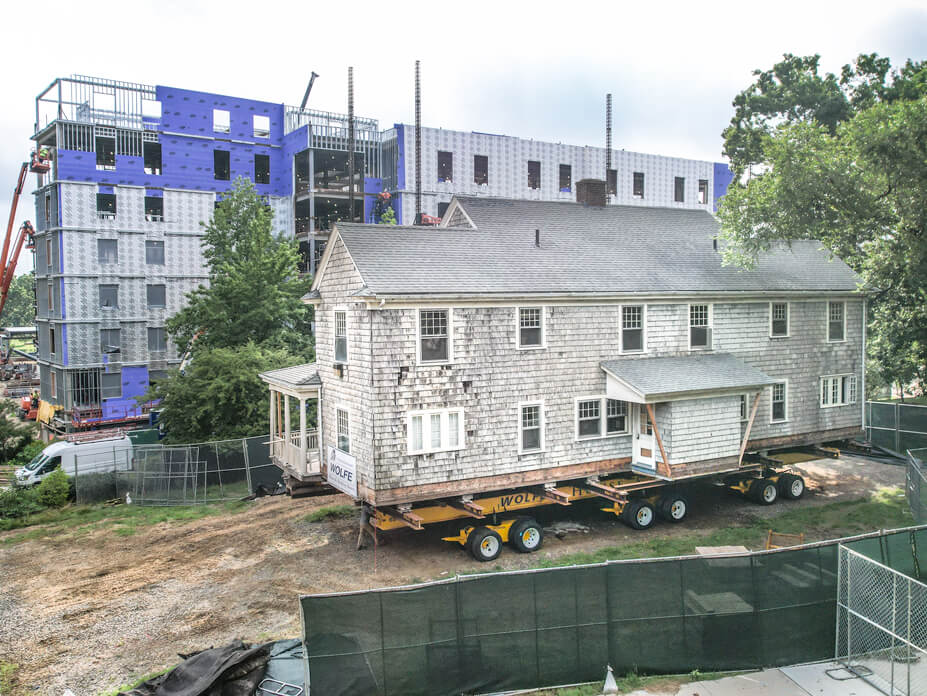 University of Connecticut house on dollies with apartment building in background