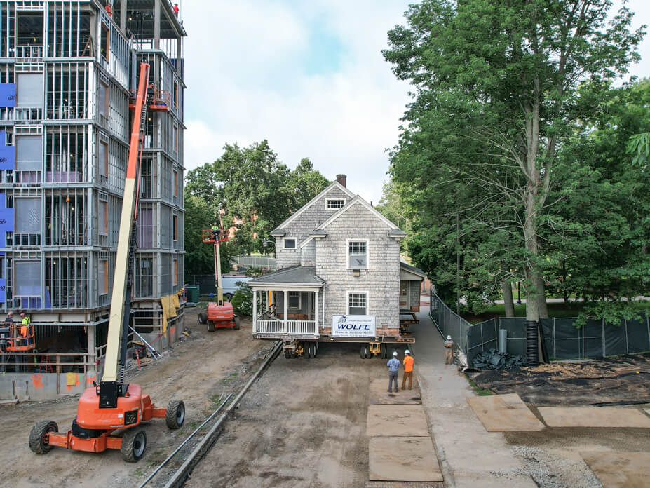 UConn house moves down street with crane in foreground