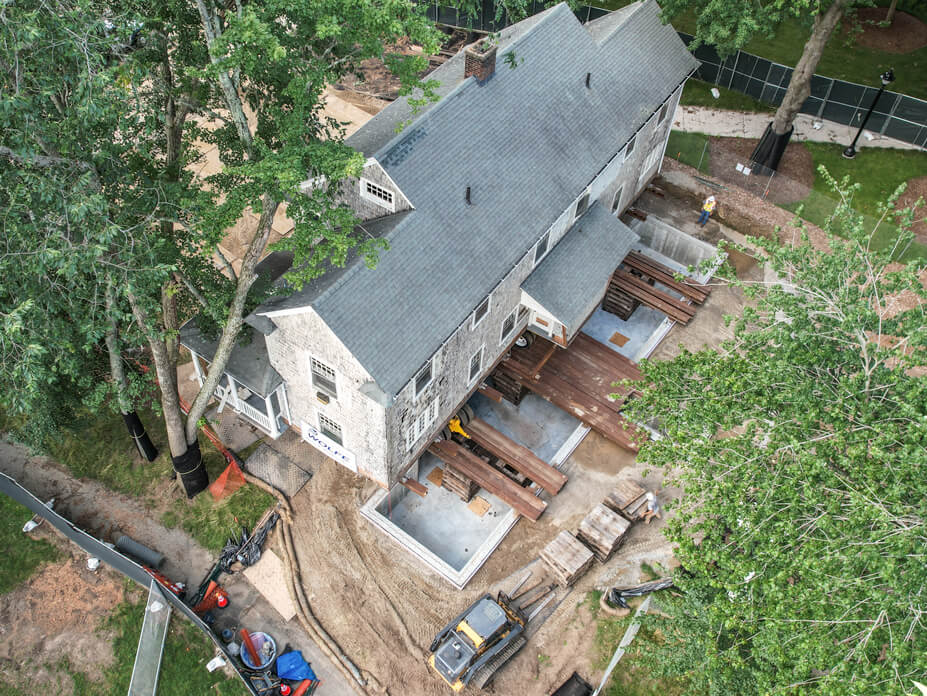 Aerial shot of house on steel beams being slid over foundation