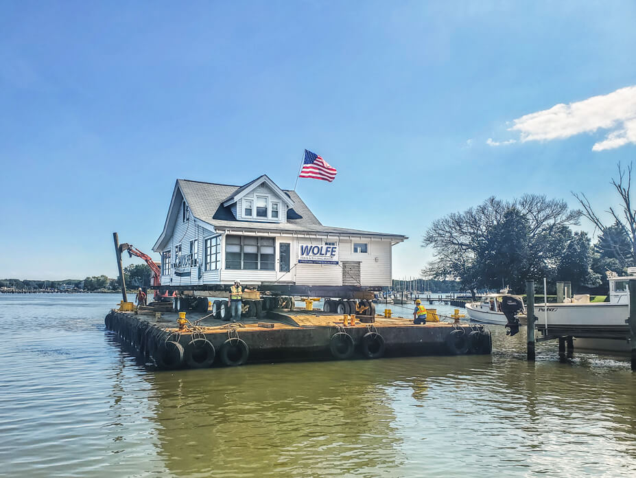 A docked barge with a house on it sits in the West River