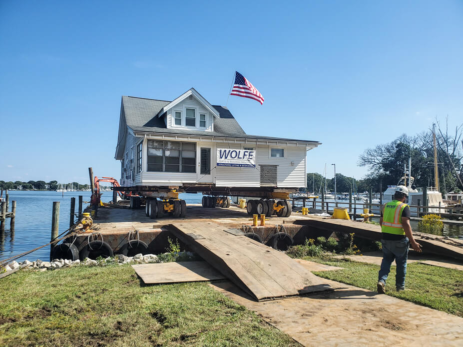 Wolfe drives house up barge ramps onto barge for relocation