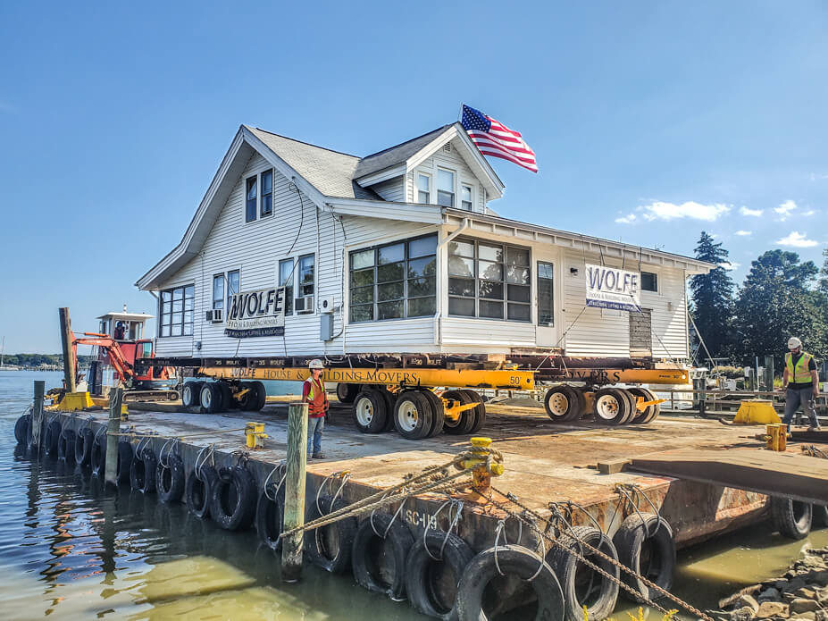 A house sits on Wolfe dollies and beans on a barge