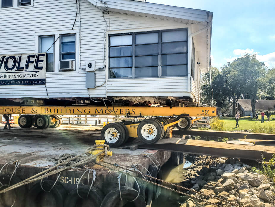 Wolfe house moving dollies drive house off of barge to  new location