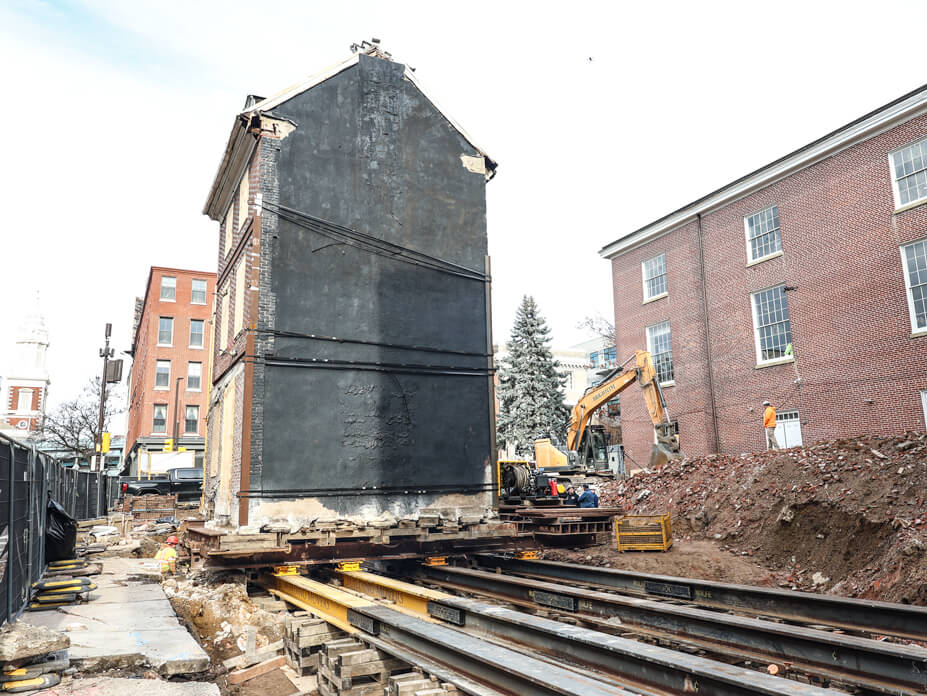 Historic 3-story brick house sit on steel beams for relocation