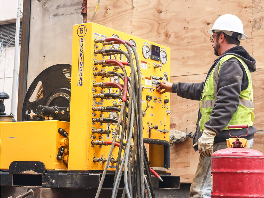 A Wolfe House Movers foreman uses a unified jacking machine