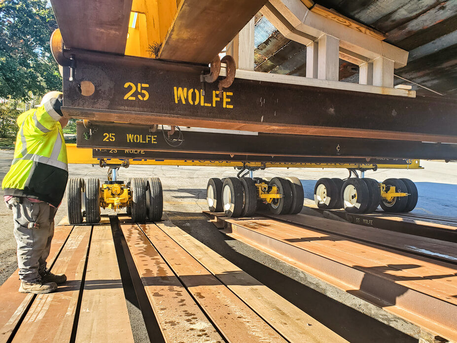 A Wolfe operator guides dollies with Sequoia over barge ramps