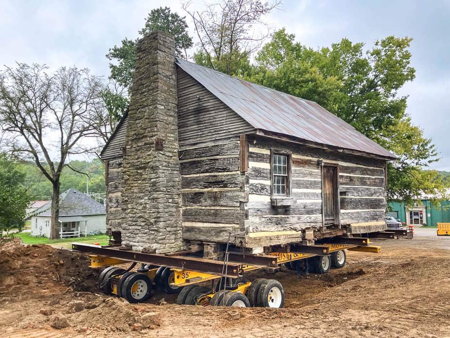 Wolfe dollies under historic log cabin