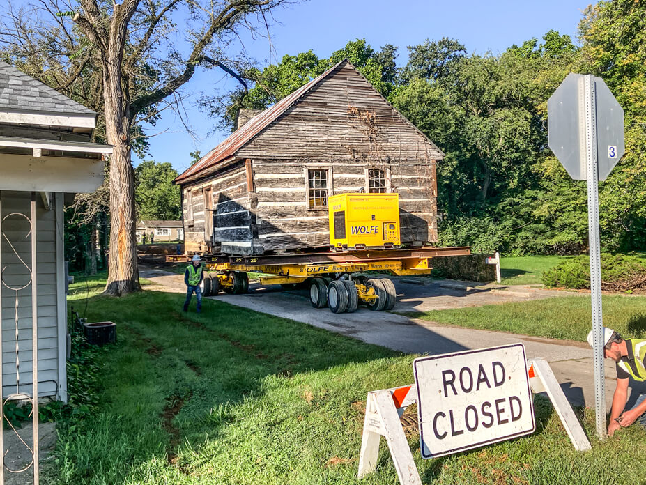 Log cabin on house moving dollies with 