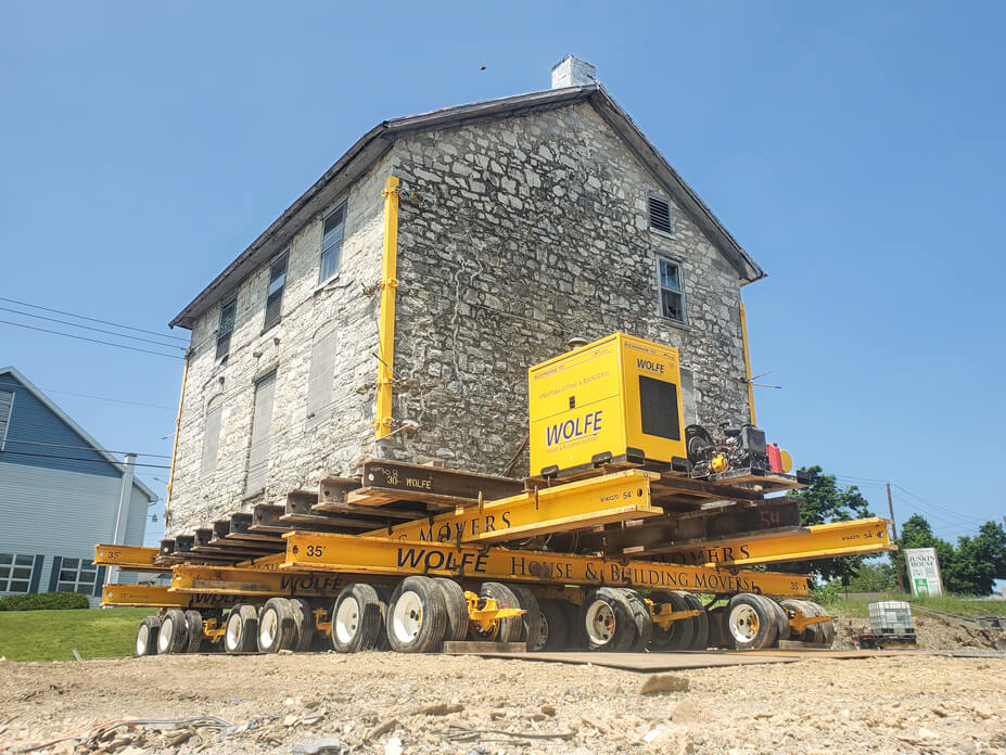 Dollies and beams support Junkin house during relocation