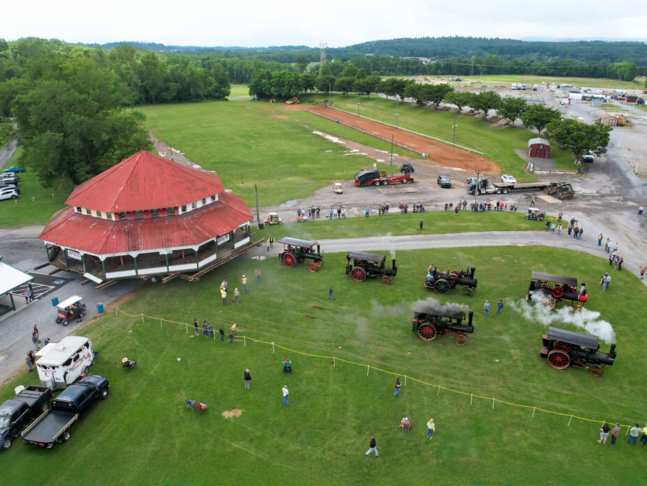 Aerial view of the Williams Grove carousel building with historic steam engines lined up in front of it