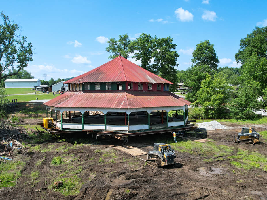 Skidsteers lay steel plate along the move route as Wolfe drives the Williams Grove Carousel house to the new site