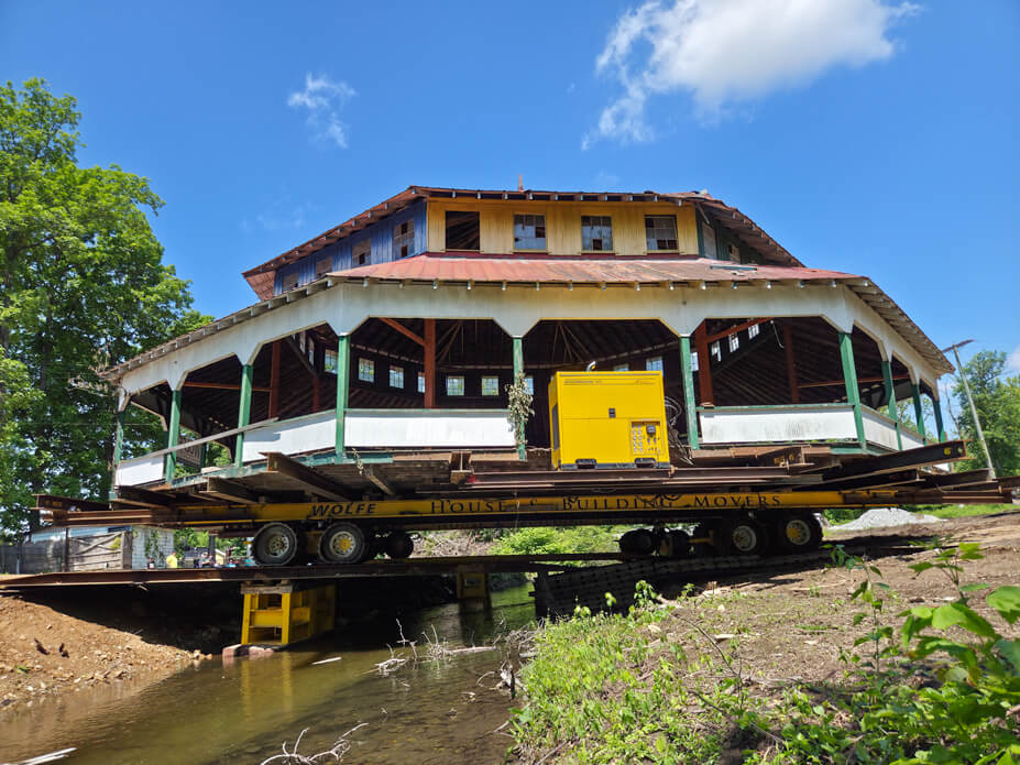 Wolfe House Movers drives the  Williams Grove carousel building over steel beams to cross a creek in the move route