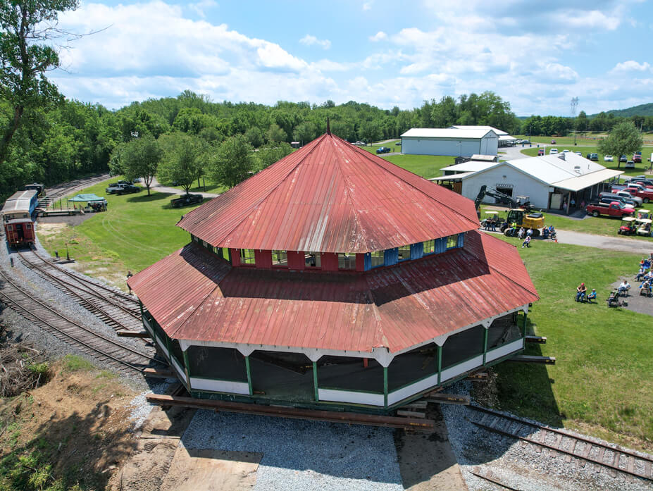 Aerial view of Wolfe House Movers driving the Williams Grove carousel house over railroad tracks