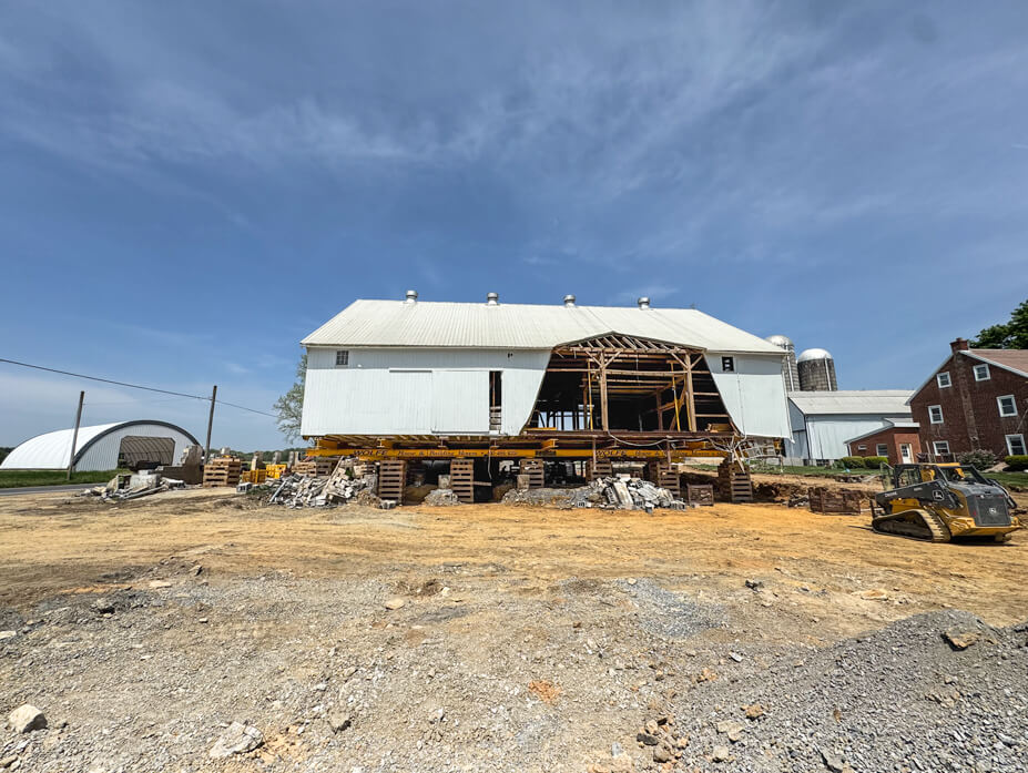 Timber frame barn with crib piles under it at new location
